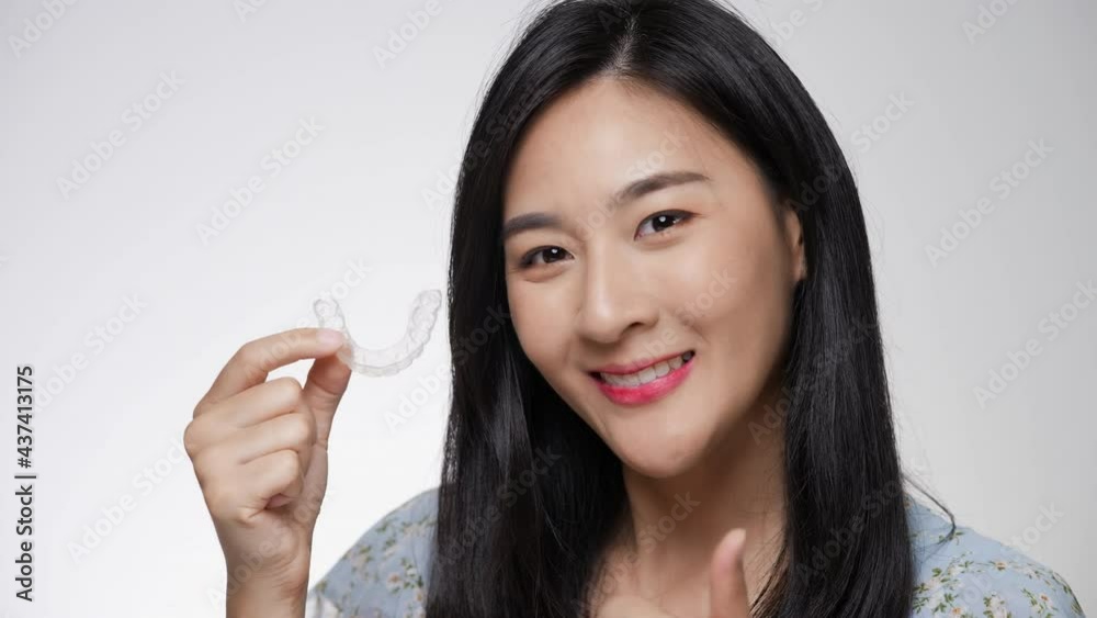Woman wearing orthodontic silicone invisalign trainer. Mobile orthodontic appliance for dental correction. tooth whitening systems. Woman wearing orthodontic silicone invisalign trainer. Mobile orthodontic appliance for dental correction. tooth whitening systems.