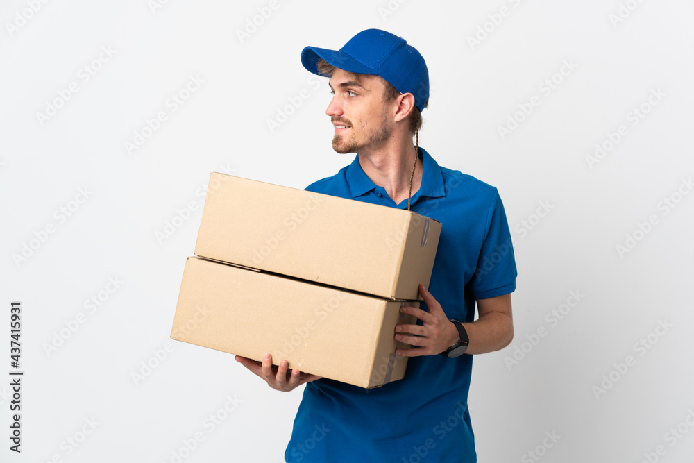 Young delivery blonde man isolated on white background looking side Young delivery blonde man isolated on white background looking side