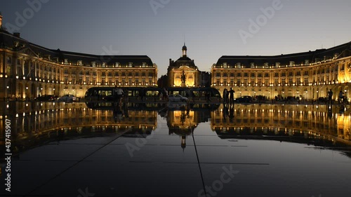 The Water Mirror of the Place de la Bourse at dusk with the tram and the silhouettes of people, Bordeaux photo