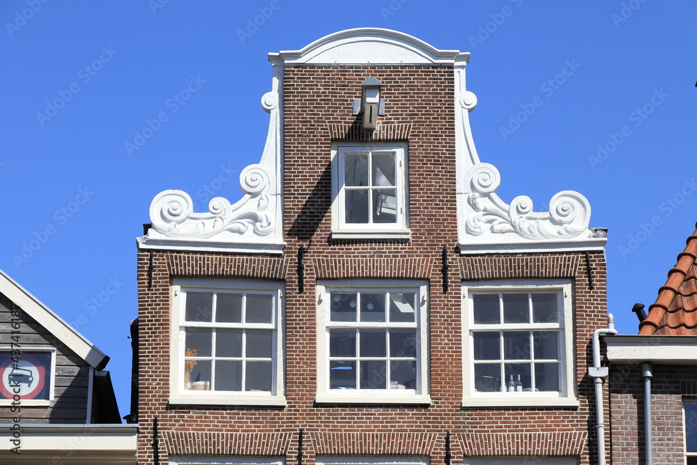 Amsterdam Jordaan Historic House Facade with Neck Gable Detail Against a Blue Sky