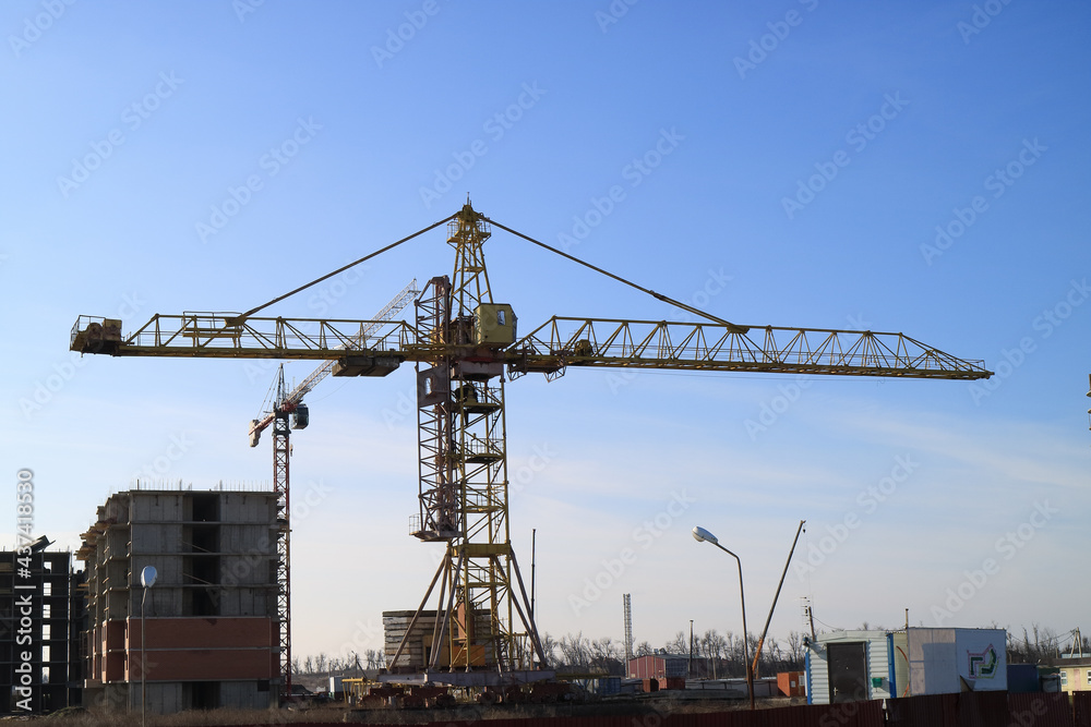 Tower cranes are working on the construction of a new house. Lifting crane. Tower cranes are working on the construction of a new house. Lifting crane.