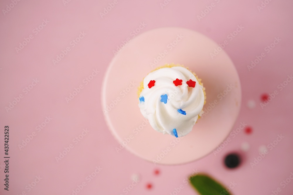 Single frosted cupcake isolated on light pink bvackground with copy space