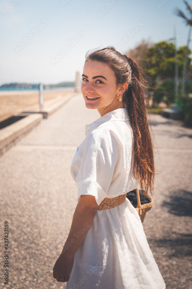 Beautiful girl with a white dress walking thorugh a coast village Beautiful girl with a white dress walking thorugh a coast village