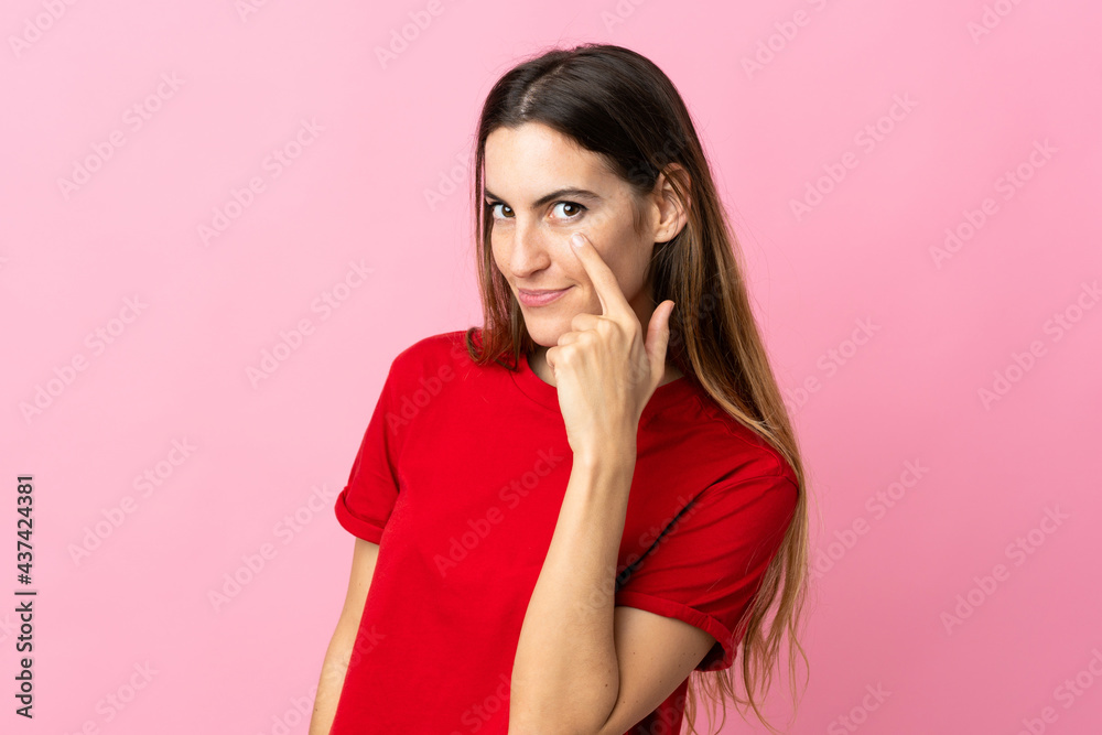 Young caucasian woman isolated on pink background showing something Young caucasian woman isolated on pink background showing something