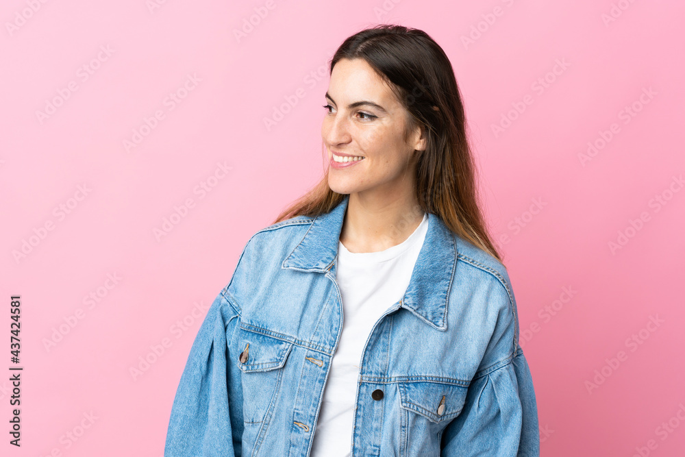 Young caucasian woman isolated on pink background looking to the side and smiling Young caucasian woman isolated on pink background looking to the side and smiling