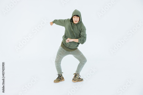 A man is performing a graceful dance in a white studio, performer masculine is a performance dancer, sportswear movement posing. © topkritsada