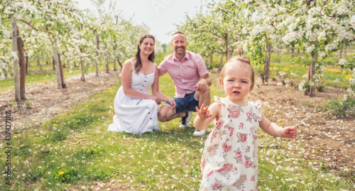 portrait of family and baby girl outdoors in apple tree flower