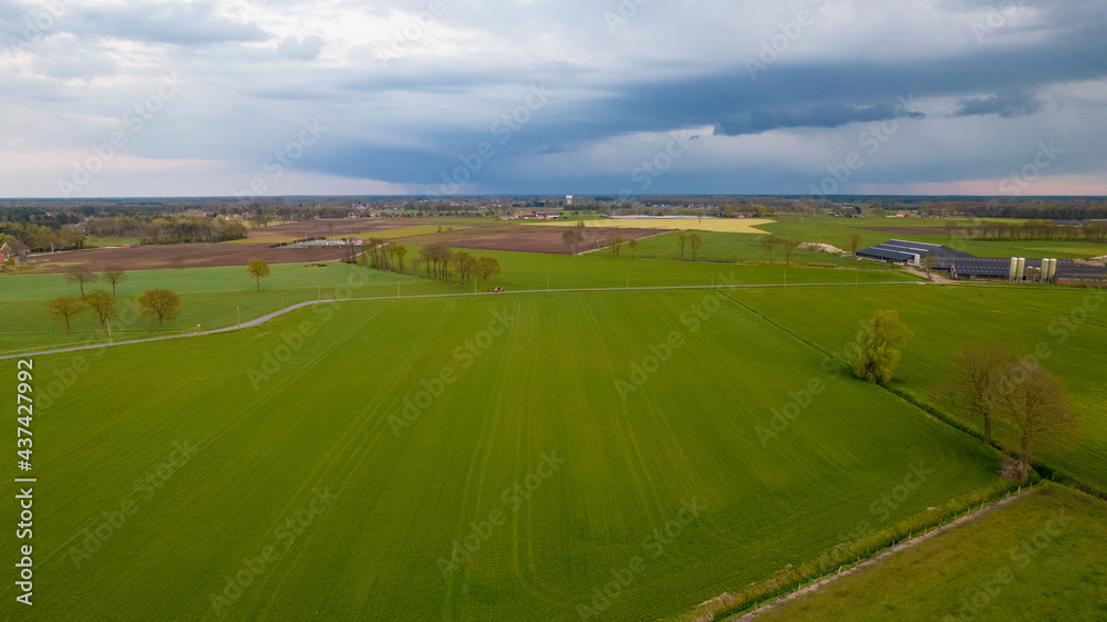 Aerial view of an evening sky over the fields overcast with thunder storm clouds coming in on the sunrise or sunset, taken with drone. High quality photo