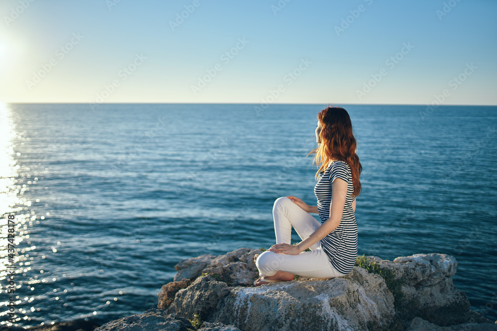 woman on the sea in the mountains in the evening at sunset high cliffs mountains
