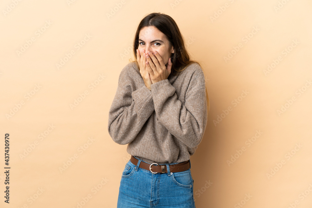 Young caucasian woman over isolated background happy and smiling covering mouth with hands Young caucasian woman over isolated background happy and smiling covering mouth with hands