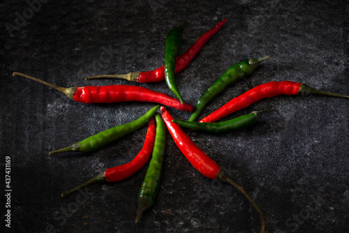 Red hot chili peppers red and green on a dark background. Studio low key dark mood food photography 