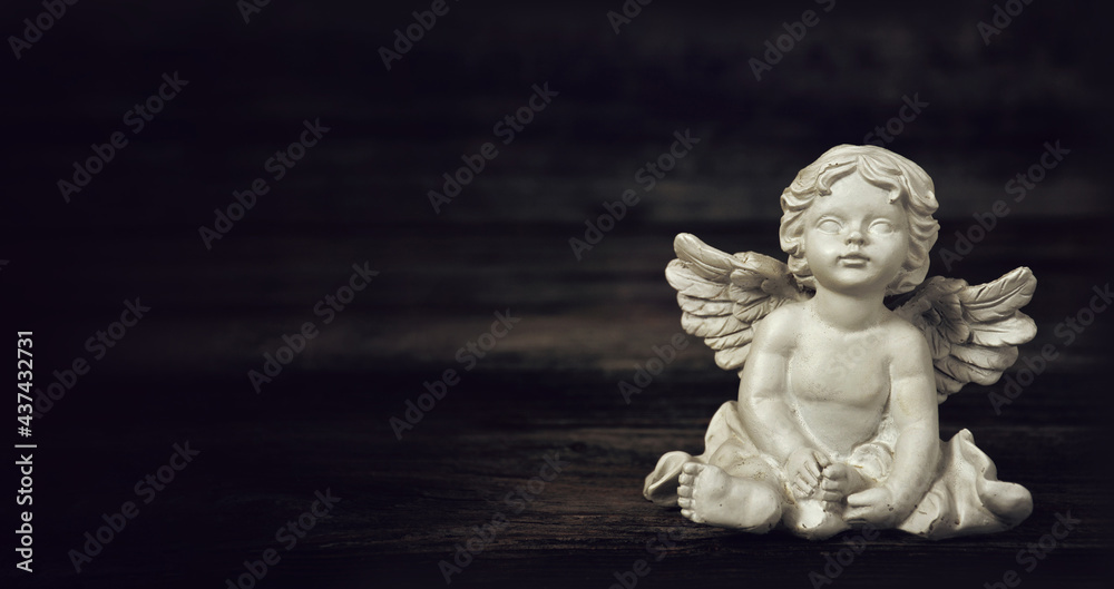 Angel on dark wooden background with copy space. Condolence card
