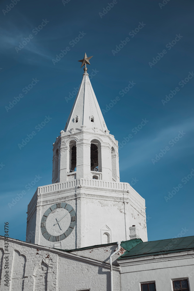 An old tower made of white stone against a blue sky. Ancient architecture. Beautiful stone tower.