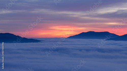 Sunrise with a sea of clouds over the Sau Reservoir seen from Roca del Migdia summit (Collsacabra, Catalonia, Spain)