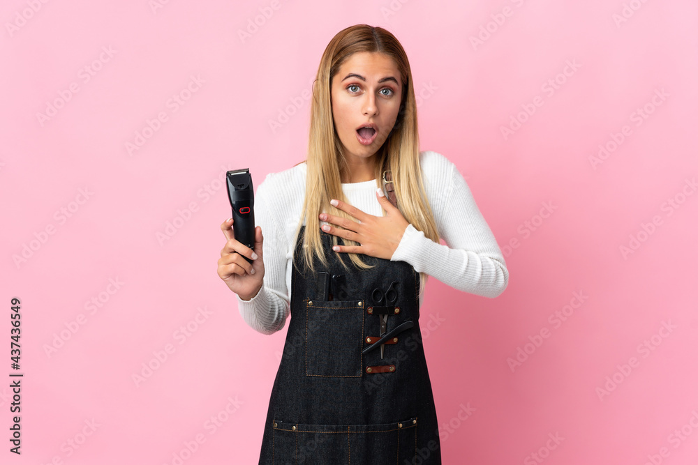 Young hairdresser woman isolated on pink background surprised and shocked while looking right Young hairdresser woman isolated on pink background surprised and shocked while looking right