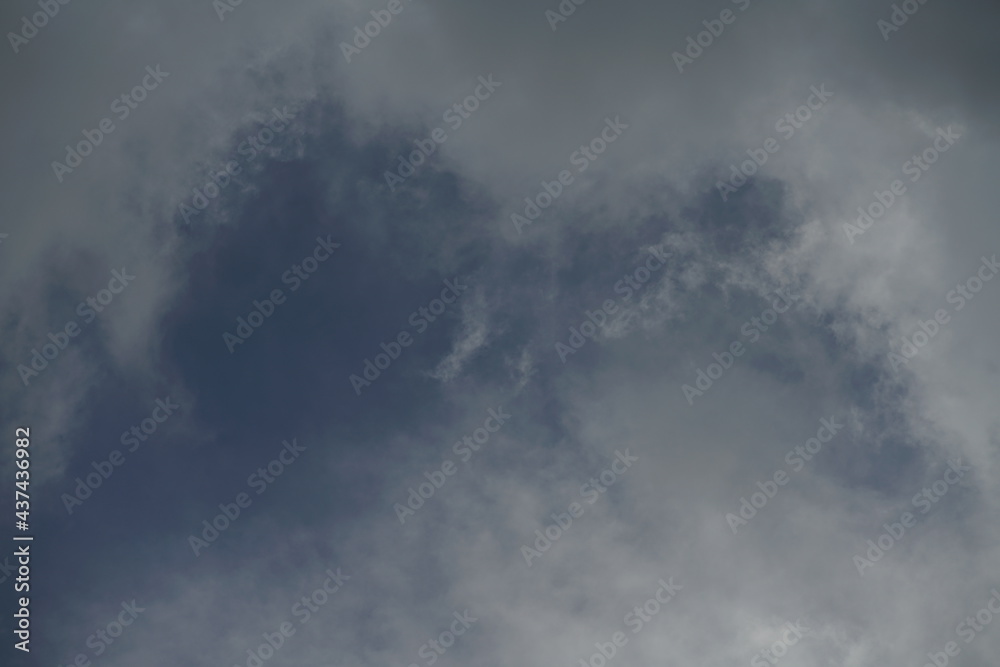 Blaue Wolken am Himmel eines aufziehenden Gewitters mit unterschiedlichen Grautönen und Farben