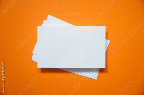 mock up of horizontal business card on orange background, top view.