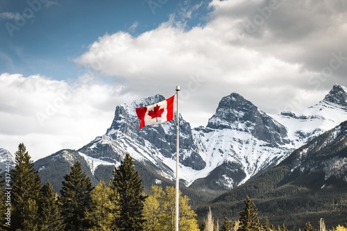 Canadian Flag with Three Sisters snowy Mountain Range in the Background