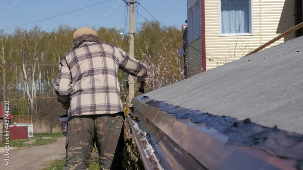 Smearing of seams with bituminous mastic. Preparation for laying a soft roof. Roofing works in a private house. Smearing of seams with bituminous mastic. Preparation for laying a soft roof. Roofing works in a private house.