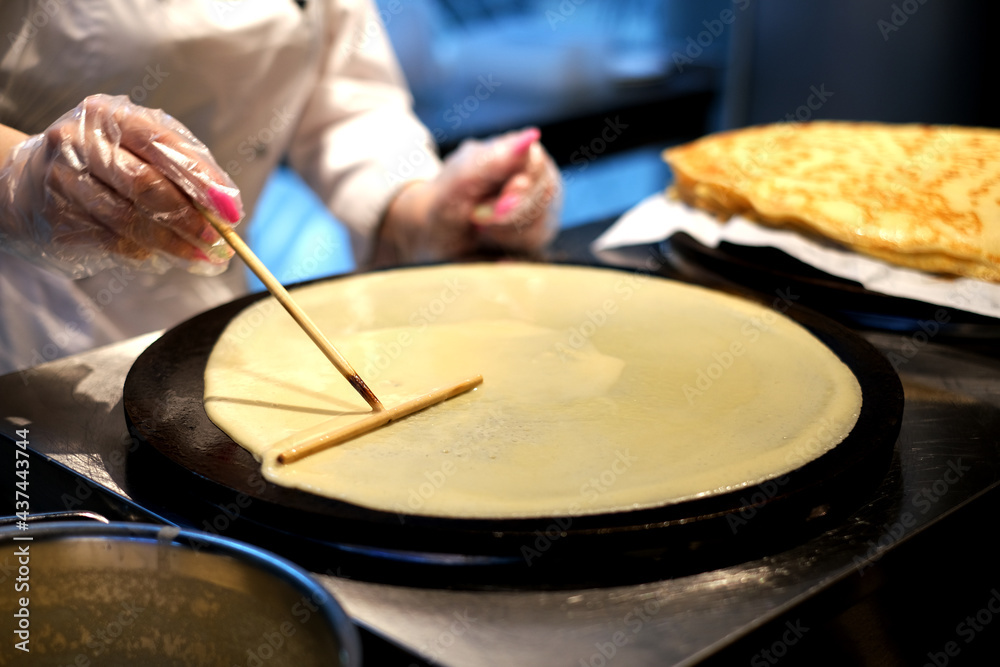 Fototapeta premium woman prepares pancakes in a cafe. pancake and pancake festival