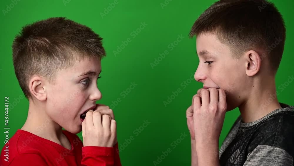 Guys on a green background, boys smiling, children wear dental plaques, crooked teeth in children. Guys on a green background, boys smiling, children wear dental plaques, crooked teeth in children.