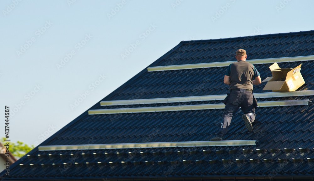 Fototapeta premium Installing modern black solar panels on the roof