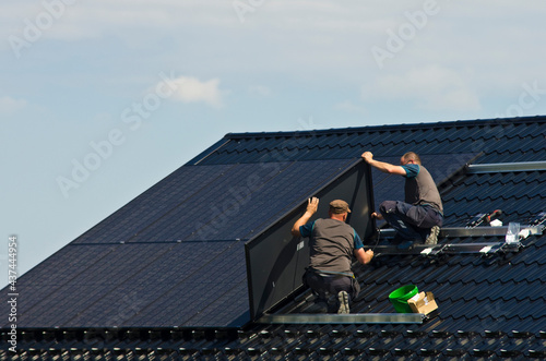 Installing modern black solar panels on the roof