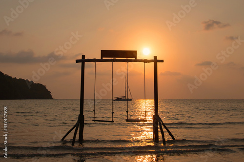 Summer vacation concept. Beautiful silhouette empty wood swing sunset or sunrise on the beach in Phuket  Thailand.