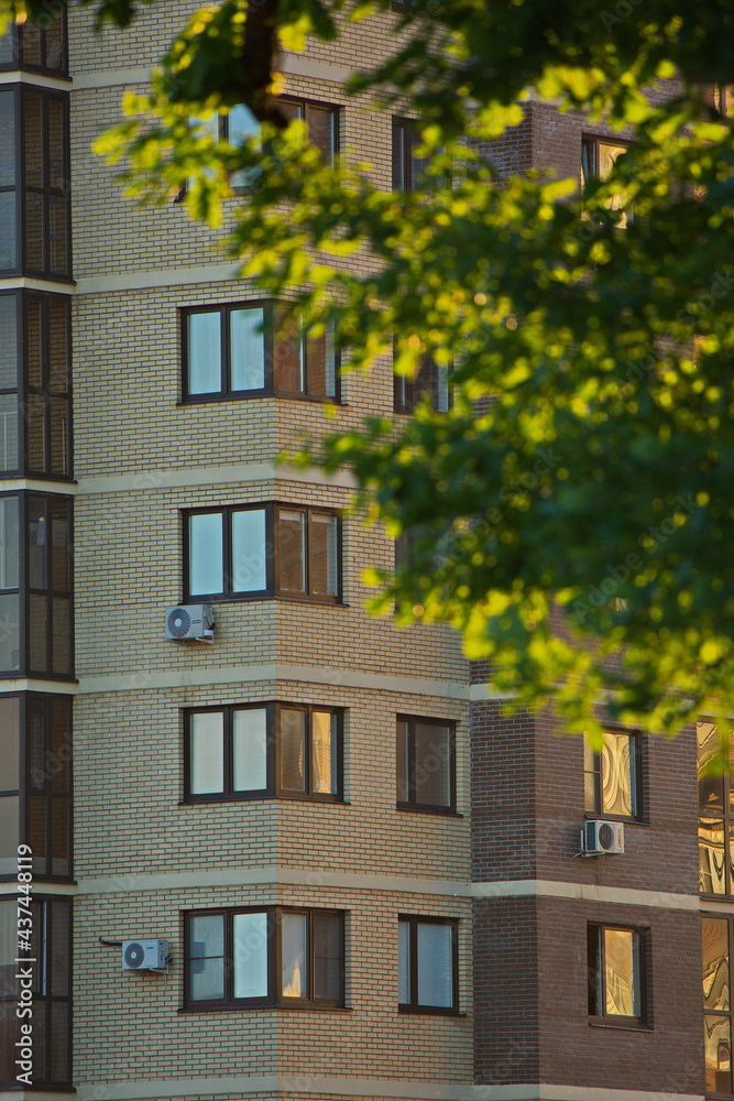 Reflections of a summer sunset in the windows of houses.