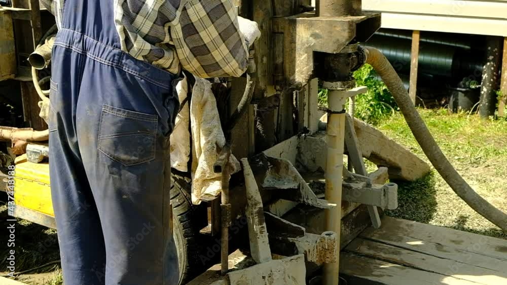 The drilling rig is drilling the ground. The worker started the mechanism of the well device. Search for water at depth. Russia. Day. Summer. The drilling rig is drilling the ground. The worker started the mechanism of the well device. Search for water at depth. Russia. Day. Summer.
