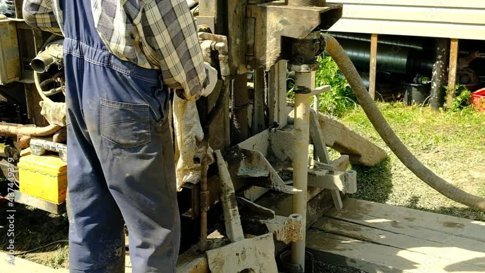 The drilling rig is drilling the ground. The worker started the mechanism of the well device. Search for water at depth. Russia. Day. Summer. The drilling rig is drilling the ground. The worker started the mechanism of the well device. Search for water at depth. Russia. Day. Summer.