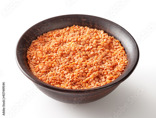 Red lentils in ceramic bowl isolated on white background