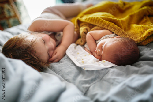 cute baby siblings sleep together, newborn baby and toddler older sister, sibling relationship in the family when the youngest was born photo