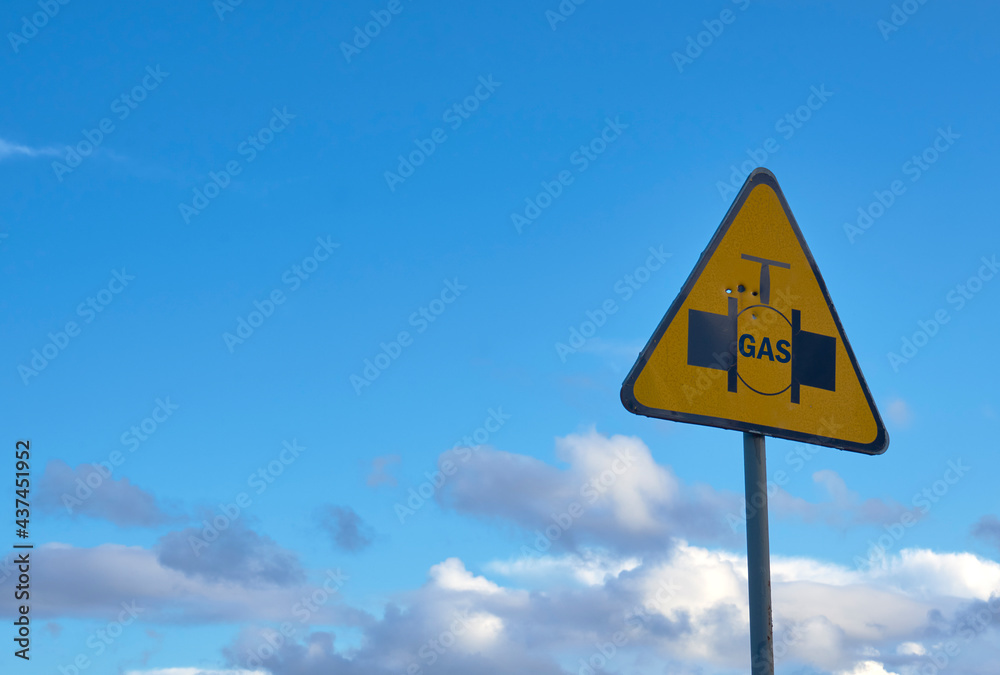 underground pipeline safety sign with gas, against the background of the cloudy sky underground pipeline safety sign with gas, against the background of the cloudy sky