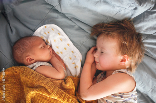 cute baby siblings sleep together, newborn baby and toddler older sister, sibling relationship in the family when the youngest was born photo