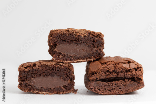 A pile of brownies stuffed with chocolate on white background.