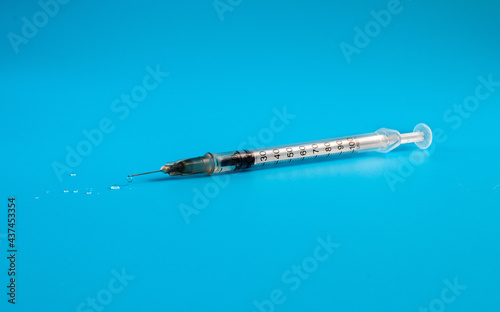 Medical insulin syringe with drops of medicine.