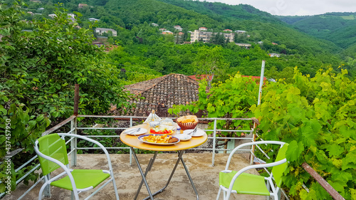 Breakfast on the roof among the vineyards with beautiful views of the green mountains. Sighnaghi, Georgia photo