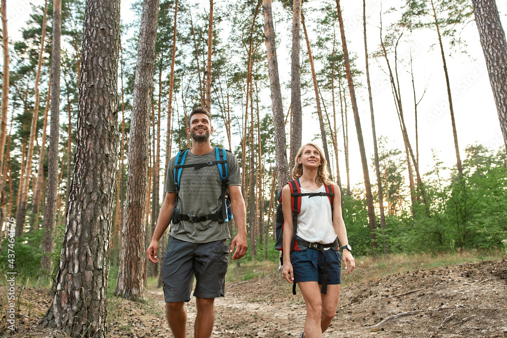 Laughing young caucasian couple trekking in wood Laughing young caucasian couple trekking in wood