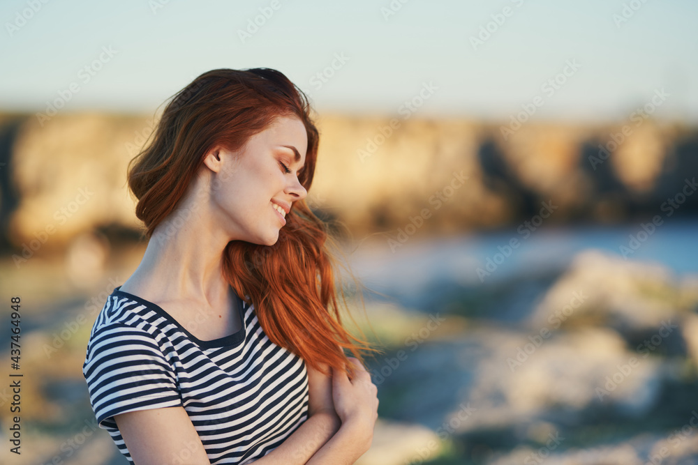 traveler in a striped T-shirt in the mountains near the river in nature traveler in a striped T-shirt in the mountains near the river in nature