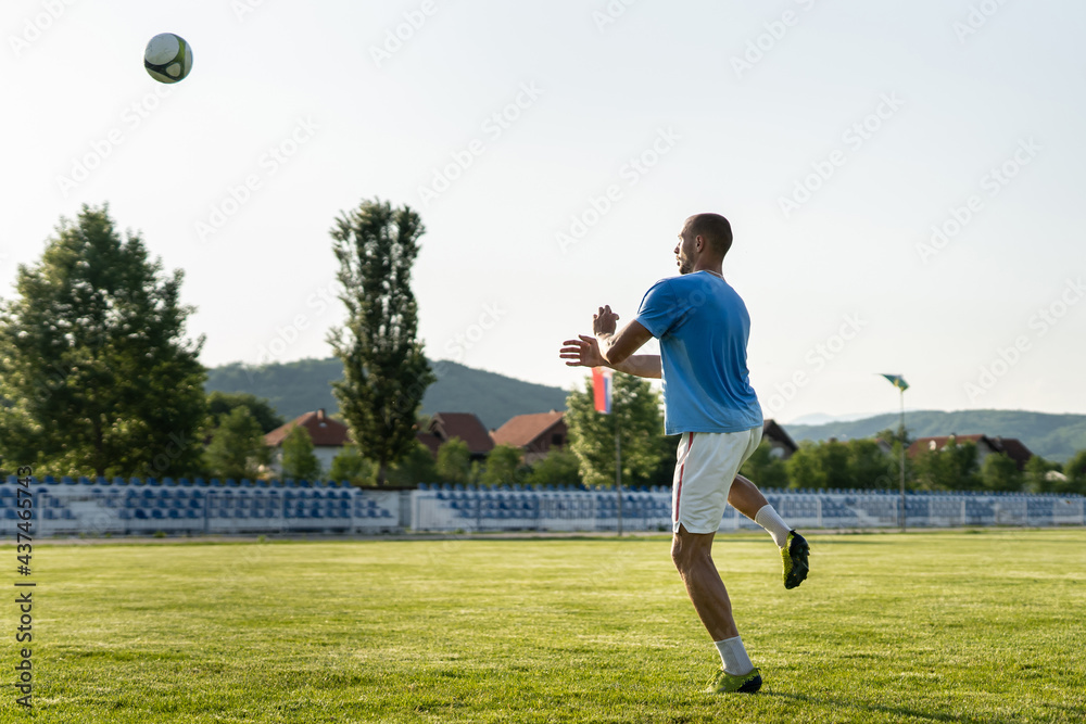 Full length soccer football player kicking the ball on game or training header