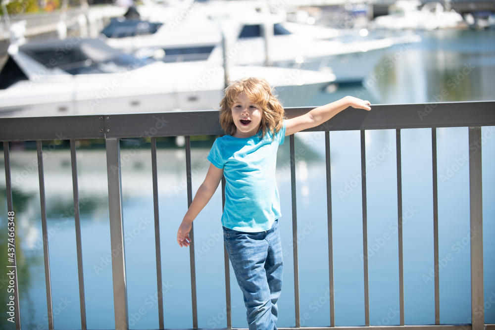 Vacation time. Happy kid stand at quay railing. Summer vacation. Summertime. Vacay mode
