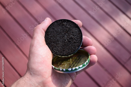 Can of Chewing Tobacco Held in a Hand photo