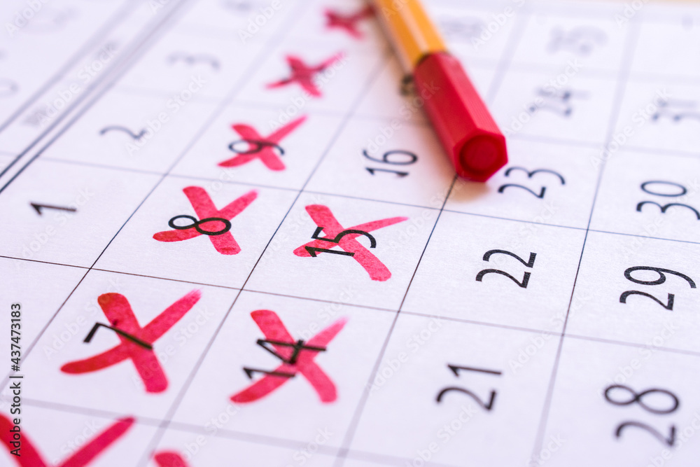 Red cross marked with red marker on calendar Red cross marked with red marker on calendar