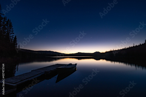Fototapeta Naklejka Na Ścianę i Meble -  Horizon reflection over the still waters of a lake at night, with starry sky, Quebec, Canada