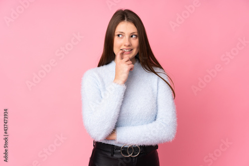 Teenager caucasian girl isolated on pink background nervous and scared © luismolinero