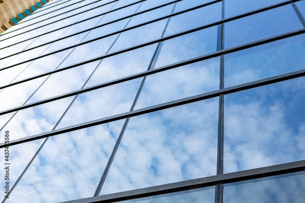 Glass skyscraper against blue sky, view from bottom Glass skyscraper against blue sky, view from bottom