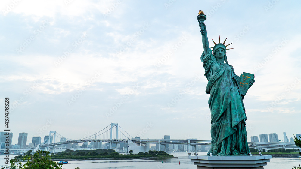 Fototapeta premium Statue of Liberty and rainbow bridge view at the afternoon time in Odaiba area, Tokyo, Japan