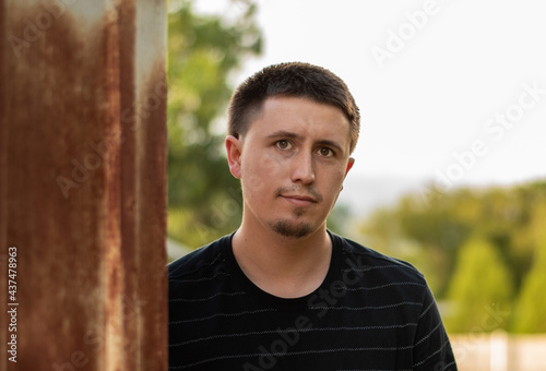 Self protrait by a rusty shed with bokeh background