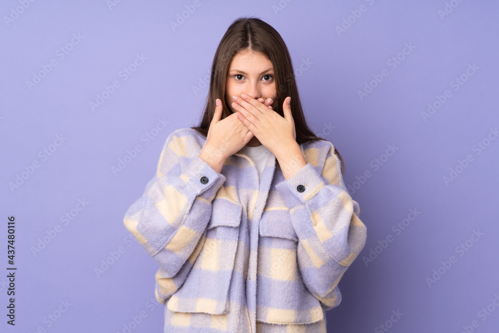 Teenager caucasian girl isolated on purple background covering mouth with hands Teenager caucasian girl isolated on purple background covering mouth with hands
